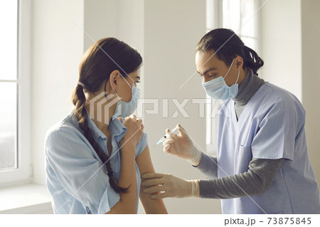 Young woman getting modern Covid-19 vaccine during vaccination campaign at clinic 73875845