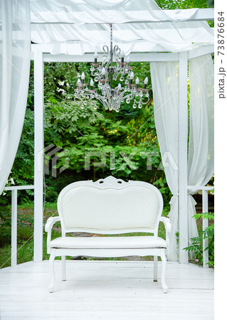 Summer elegant elegant gazebo in the lush gardens. Exquisite classic sofa gazebo. 73876684