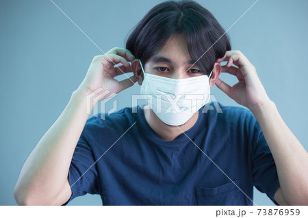Close up of young man in sterile face mask isolated background. Epidemic pandemic coronavirus 2019, covid-19 flu virus concept. Close up of young man in sterile face mask isolated background. Epidemic pandemic coronavirus 2019, covid-19 flu virus concept. 73876959