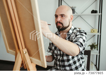 Creative home leisure. Man does easel drawing 73877805
