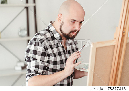 Young painter doing easel drawing at art studio 73877818