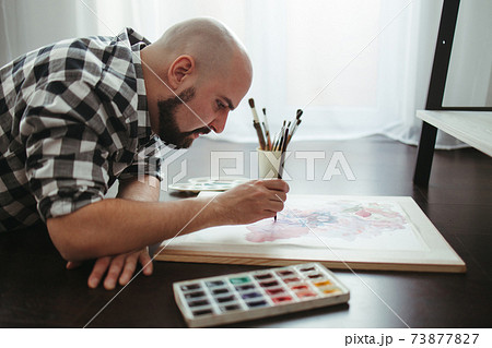 Man drawing laying on the floor of design studio Man drawing laying on the floor of design studio 73877827