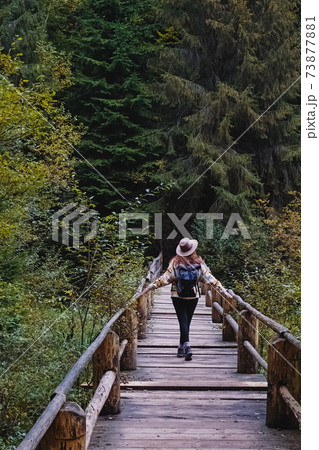 Young woman in hat enjoying nature in autumn mountains. Young woman in hat enjoying nature in autumn mountains. 73877881