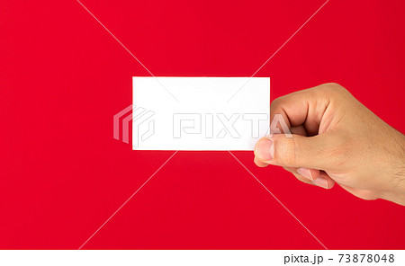 Man showing blank white business card isolated on red background Man showing blank white business card isolated on red background 73878048