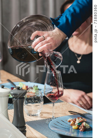 sommelier pouring champagne into glass at wine tasting 73880360