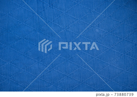 The texture of a cotton kimono for judo classes. Blue fabric close-up. The view from the top. 73880739