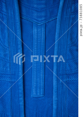 The texture of a cotton kimono for judo classes. Blue fabric close-up. The view from the top. The texture of a cotton kimono for judo classes. Blue fabric close-up. The view from the top. 73881085