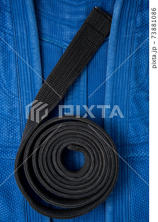 The view from the top. Kimono for judo classes and a black belt. The kimono is blue. Background, texture. The view from the top. Kimono for judo classes and a black belt. The kimono is blue. Background, texture. 73881086