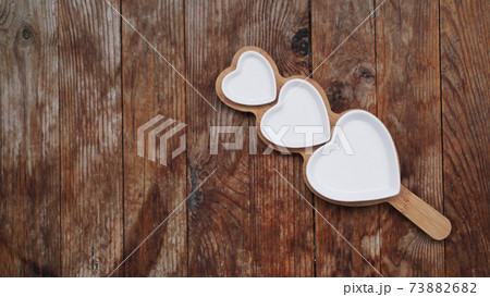 Heart shaped plates on wooden table 73882682