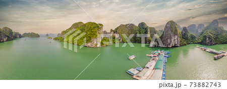 Aerial view panorama of floating fishing village and rock island, Halong Bay, Vietnam, Southeast Asia. UNESCO World Heritage Site. Junk boat cruise to Ha Long Bay. Popular landmark of Vietnam Aerial view panorama of floating fishing village and rock island, Halong Bay, Vietnam, Southeast Asia. UNESCO World Heritage Site. Junk boat cruise to Ha Long Bay. Popular landmark of Vietnam 73882743