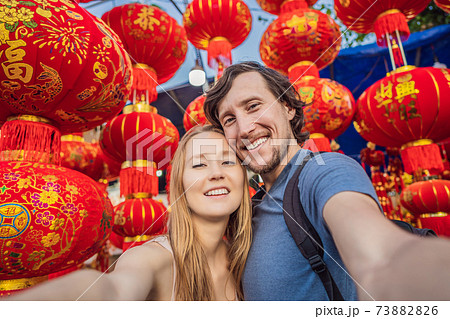 Caucasian tourists happy couple man and woman in Tet holidays. Vietnam Chinese Lunar New Year in springtime Caucasian tourists happy couple man and woman in Tet holidays. Vietnam Chinese Lunar New Year in springtime 73882826