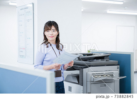 オフィスでコピーをとる女性社員 オフィスでコピーをとる女性社員 73882845