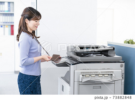 オフィスでコピーをとる女性社員 オフィスでコピーをとる女性社員 73882848