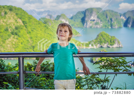 Boy traveler in Halong Bay. Vietnam. Travel to Asia, happiness emotion, summer holiday concept. Picturesque sea landscape. Ha Long Bay, Vietnam. After coronavirus COVID 19 73882880