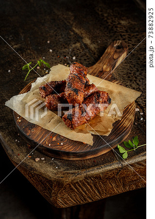 Grill house concept. Grilled, roasted tasty sausage with french fries on the old wooden cutting board. 73882925