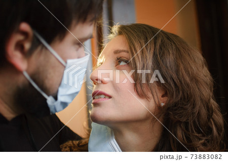 Happy couple in love, man and woman are trying to kiss each other in protective medical mask. Virus protection concept 73883082