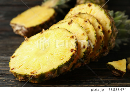 Ripe cutted pineapple on wooden background, close up Ripe cutted pineapple on wooden background, close up 73883474