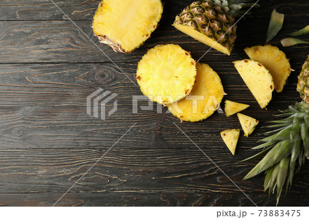 Ripe pineapples and slices on wooden background, top view 73883475