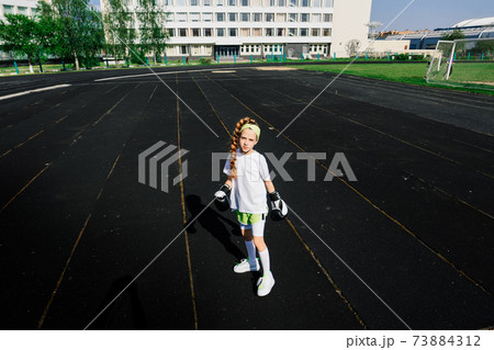Female child boxer in gloves, feminism concept. Back to school, physical training lesson. 73884312