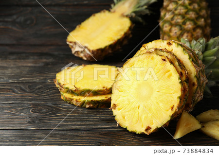 Ripe pineapples on wooden background, space for text 73884834