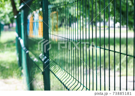 A blue mesh fence close up in summer 73885181