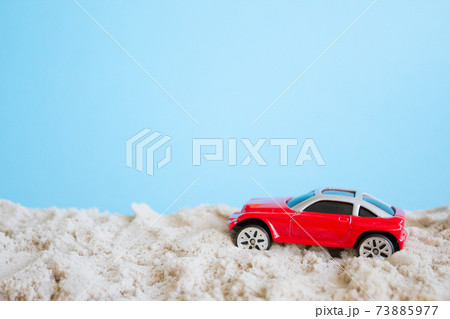 Red toy car, Summer concept. Car on a sandy beach 73885977