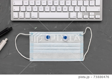 Mask and computer keyboard. Office and Covid-19 73886476