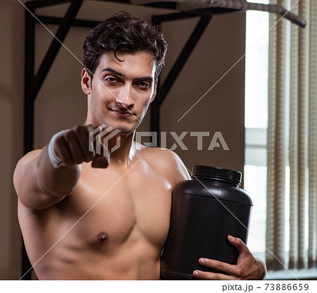 Man with nutrient supplements in sports gym 73886659