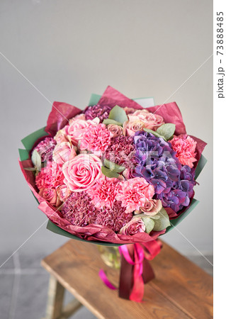 purple and pink bouquet of beautiful flowers on wooden table. Floristry concept. Spring colors. the work of the florist at a flower shop. 73888485
