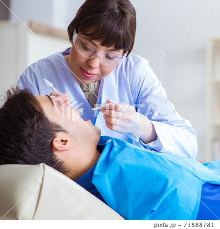 Woman dentist doctor with male patient in hospital 73888781