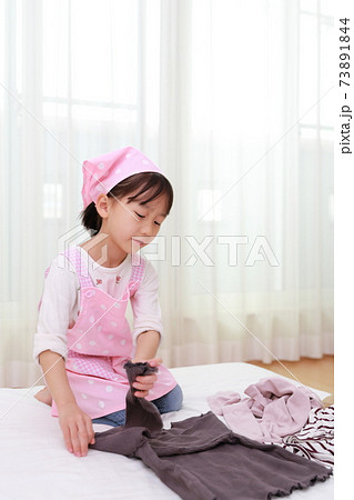 洗濯物をたたむお手伝をする5歳の女の子の写真素材 [73891844] - PIXTA