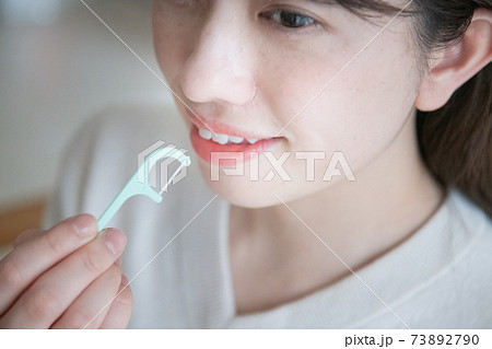 デンタルフロス・糸ようじを使う女性の口元 デンタルフロス・糸ようじを使う女性の口元 73892790