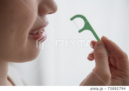 デンタルフロス・糸ようじを使う女性の口元 デンタルフロス・糸ようじを使う女性の口元 73892794