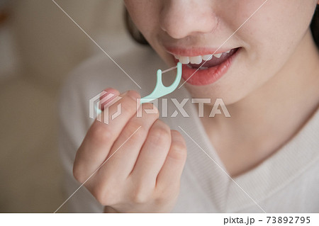 デンタルフロス・糸ようじを使う女性の口元 73892795