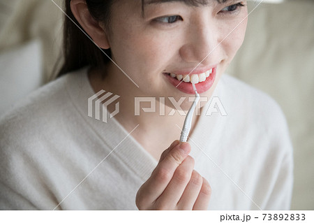 歯間ブラシを使う女性 73892833