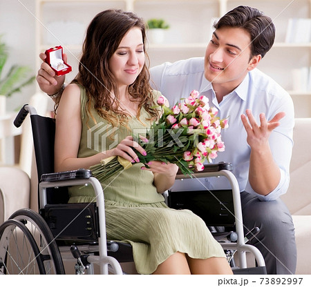 Man making marriage proposal to disabled woman on wheelchair Man making marriage proposal to disabled woman on wheelchair 73892997