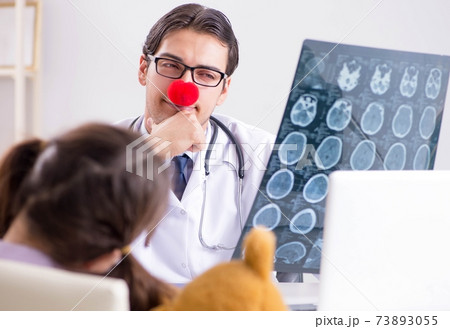 Funny pediatrician with little girl at regular check-up 73893055
