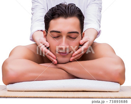 Handsome man during spa massaging session Handsome man during spa massaging session 73893686