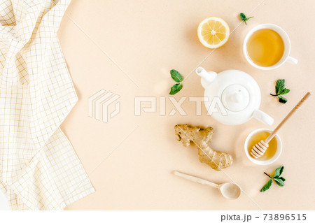 Herbal tea with mint, ginger, lemon, honey and other herbs on yellow background. Flat lay, top view. 73896515