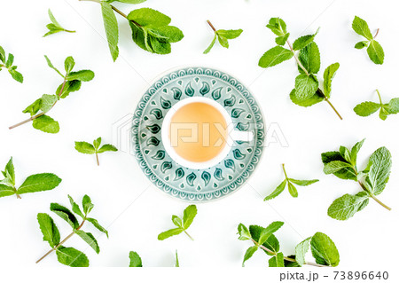 Mint tea with frame made of mint leaves isolated on white background. Set of peppermint. Mint Pattern. Flat lay. Top view. Mint tea with frame made of mint leaves isolated on white background. Set of peppermint. Mint Pattern. Flat lay. Top view. 73896640