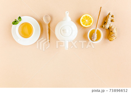 Herbal tea with mint, ginger, lemon, honey and other herbs on yellow background. Flat lay, top view. 73896652