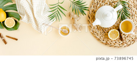 Herbal tea with mint, ginger, lemon, honey and other herbs on yellow background. Flat lay, top view. Herbal tea with mint, ginger, lemon, honey and other herbs on yellow background. Flat lay, top view. 73896745