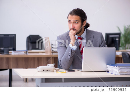 Young male employee working in the office Young male employee working in the office 73900935