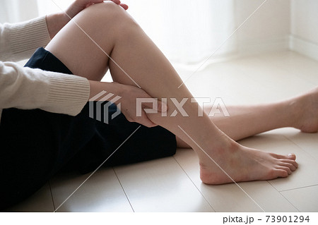 足のむくみをケアする女性 ふくらはぎをマッサージする女性の写真素材
