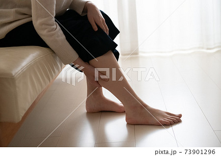 足のむくみをケアする女性 ふくらはぎをマッサージする女性の写真素材