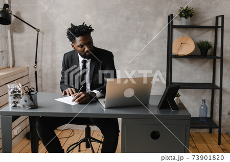 a young aspiring African-American investor works at a computer, analyzes the securities market 73901820