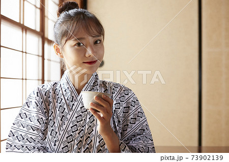 旅館でリラックスする浴衣姿の若い女性 旅館でリラックスする浴衣姿の若い女性 73902139
