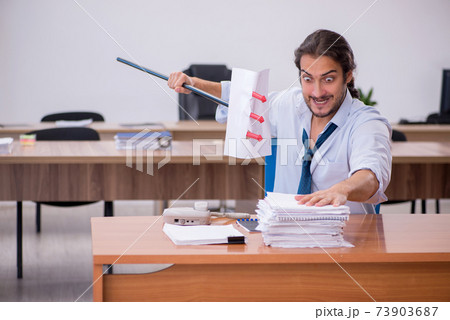 Young devil businessman holding trident in the office Young devil businessman holding trident in the office 73903687