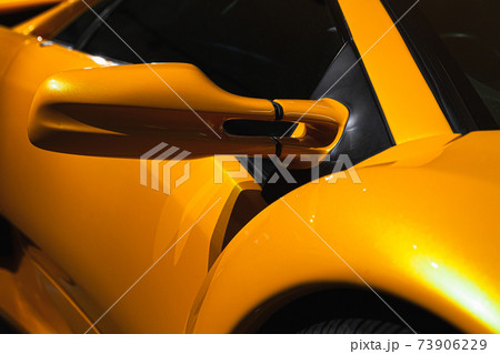 Luxury yellow sports car mirror, close-up photo Luxury yellow sports car mirror, close-up photo 73906229