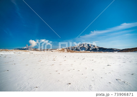 冬の青空に雪化粧した阿蘇の風景 73906871